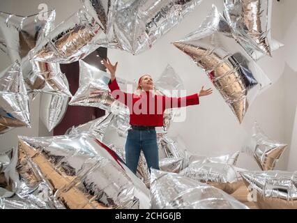 Un assistant de la galerie Tate Modern interagit avec l'installation de « Silver Clouds », lors d'une vue d'ensemble de la nouvelle exposition d'Andy Warhol à Tate Modern, Londres, qui présente des œuvres et des œuvres d'art pop classiques jamais présentées au Royaume-Uni. Photo PA. Date de la photo: Mardi 10 mars 2020. Le crédit photo devrait se lire comme suit : Dominic Lipinski/PA Wire Banque D'Images