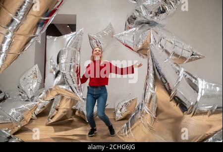 Un assistant de la galerie Tate Modern interagit avec l'installation de « Silver Clouds », lors d'une vue d'ensemble de la nouvelle exposition d'Andy Warhol à Tate Modern, Londres, qui présente des œuvres et des œuvres d'art pop classiques jamais présentées au Royaume-Uni. Photo PA. Date de la photo: Mardi 10 mars 2020. Le crédit photo devrait se lire comme suit : Dominic Lipinski/PA Wire Banque D'Images