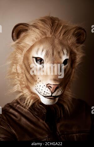 portrait d'un homme portant un masque de lion sur fond beige, avec traitement rétro Banque D'Images