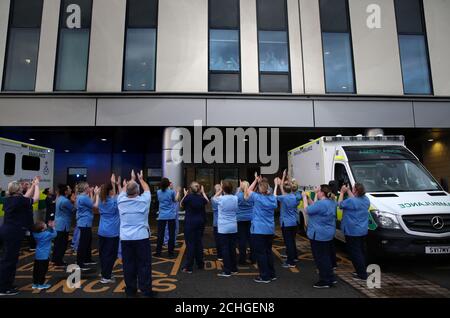 Les infirmières se sont accrochez à leurs collègues alors qu'elles regardent d'une fenêtre à l'hôpital universitaire Queen Elizabeth de Glasgow alors qu'elles se joignent aux applaudissements pour saluer les héros locaux au cours du Clap national de jeudi pour que les soignants reconnaissent et soutiennent les travailleurs et les soignants du NHS qui luttent contre la pandémie de coronavirus. Banque D'Images