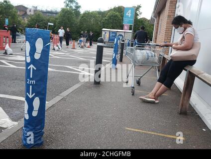 Les gens pratiquent des distanciation sociale tout en faisant la queue en dehors d'un magasin Tesco Extra à Twickenham, Londres, alors que le Royaume-Uni continue de se maintenir en position de verrouillage pour aider à freiner la propagation du coronavirus. Banque D'Images