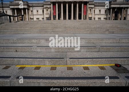 Un mètre ruban est placé contre les marqueurs de mesure impériaux intégrés aux marches menant à la National Portrait Gallery de Trafalgar Square à Londres alors que le Royaume-Uni continue de se verrouiller pour aider à freiner la propagation du coronavirus. Banque D'Images