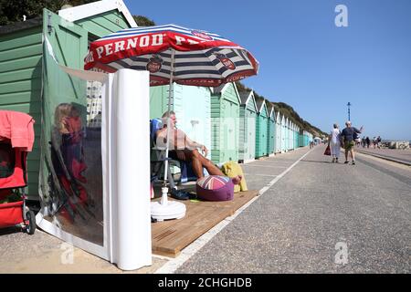 Rob Underhill (à droite) et sa femme Sally s'assoient à l'extérieur de leur cabane de plage pendant qu'ils profitent du soleil d'automne sur la plage de Bournemouth à Dorset. Banque D'Images