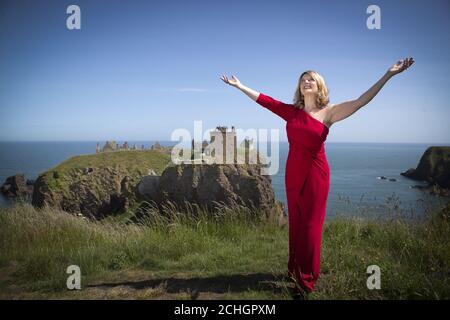 Fiona Kennedy, chanteuse, chansonnante et diffuseur écossaise, chante « Stronger for the Storm », une nouvelle chanson internationale de la paix, sur le sommet de la falaise surplombant le château de Dunnottar sur la côte de l'Aberdeenshire, Au lancement de iSing4Peace à l'occasion de l'anniversaire de la signature du Traité de Versailles qui a mis fin officiellement à la première Guerre mondiale et a rétabli la paix dans le monde. Banque D'Images