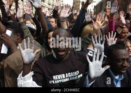 Les manifestants lèvent leurs mains peintes alors qu’ils se rassemblent devant l’ambassade du Soudan à Londres pour un rassemblement appelant à la fin de la crise au Darfour. Banque D'Images