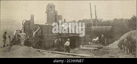 . Travaux publics . neer, 3 pierres de menwheeling, 4 hommes pierre de pellage, 2 hommes pelleingsand, 3 hommes sur les plates-formes de pesage et de mélange et un homme utilitaire. Avec cette équipe, la production quotidienne était d'environ 600 lots. De l'usine de mélange, le pansement a été transporté directement dans les wagons et transporté jusqu'au point de construction. En raison de la longue distance de la distance de trois milles dans chaque sens, la charge a été couverte par un tarpaulinto retenir autant que possible de la chaleur. En arrivant au travail, le mélange a été jeté et placé en bonne position et nivelé par des hommes withrakes et des pelles, ce qui, à faciliter Banque D'Images