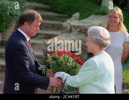 Geoff Hurst, héros à trois buts du triomphe de la coupe du monde d'Angleterre en 1966, présente à la Reine un bouquet de roses « Pride of England », récemment lancé par la football Association, lors de sa visite au Chelsea Flower Show à Londres. Banque D'Images