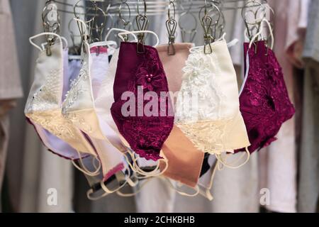 Tissu de dentelle violet et blanc masques réutilisables suspendus sur cintre de vêtements.faire le masque de tissu pour prévenir l'épidémie du virus Covid-19 deviennent populaires. Banque D'Images