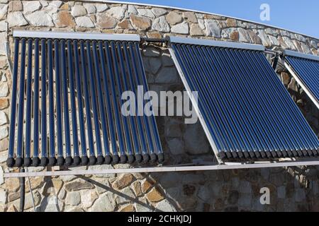 Système de chauffage solaire de l'eau installé sur le mur ou le toit de la maison. 3 panneaux de tubes coaxiaux en verre avec de l'eau pour accumuler la chaleur. Vue latérale. Concept évir Banque D'Images