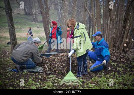 Les gens nettoient les feuilles mortes. Nettoyage public des territoires municipaux à Rezekne - Lettonie, avril 2016. Banque D'Images