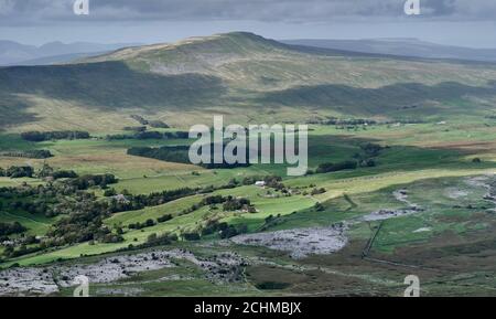 Vue nord à travers la vallée de Winterscales Beck avec Whernside Rising derrière et cicatrice calcaire exposition de roche en premier plan Banque D'Images