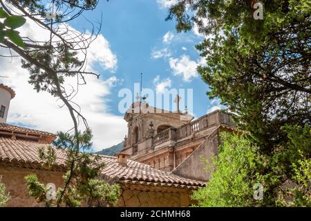 Vue sur le clocher du monastère religieux de Lluc par une journée ensoleillée, depuis la forêt méditerranéenne annexée Banque D'Images