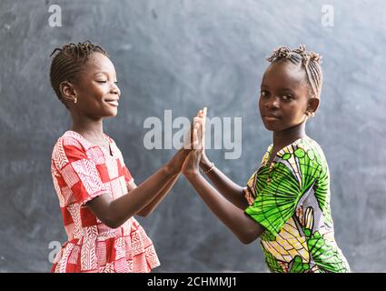 Les enfants noirs africains jouant avec les mains souriantes