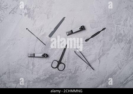 Ensemble de manucure, outils et accessoires de pédicure, fond en béton de pierre, vue de dessus Banque D'Images