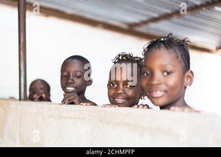 Quatre beaux enfants noirs africains souriant gaiement à Camera Banque D'Images