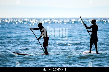 Swansea, pays de Galles, 14 septembre 2020 deux personnes sur paddleboard à Langland Bay à Swansea pendant que le Royaume-Uni se prélassent sous le soleil glorieux de septembre. Banque D'Images