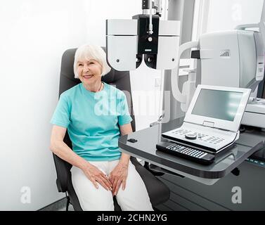 Femme âgée pendant un examen oculaire au bureau d'ophtalmologie. La vision de la femme contrôle avec un phoropter Banque D'Images