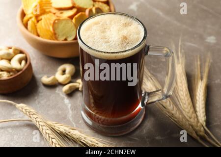 Bière, blé et encas sur fond gris, gros plan Banque D'Images