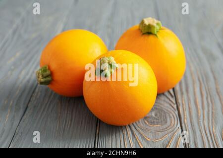 Trois courgettes rondes sur fond en bois, gros plan Banque D'Images