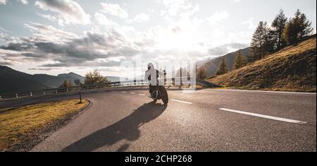 Moto pilote sur la route de montagne, grand format. Coucher de soleil spectaculaire Banque D'Images