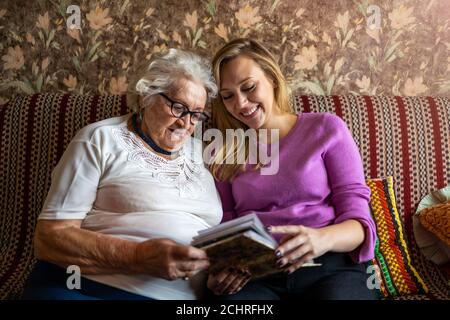 Jeune femme passant du temps avec sa grand-mère âgée à la maison Banque D'Images