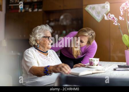 Jeune femme passant du temps avec sa grand-mère âgée à la maison Banque D'Images