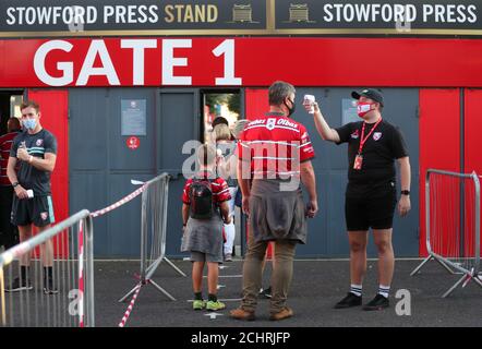 Un steward en PPE (à droite) prend la température des fans de Gloucester avant le match Gallagher Premiership au stade Kingsholm, Gloucester. Banque D'Images