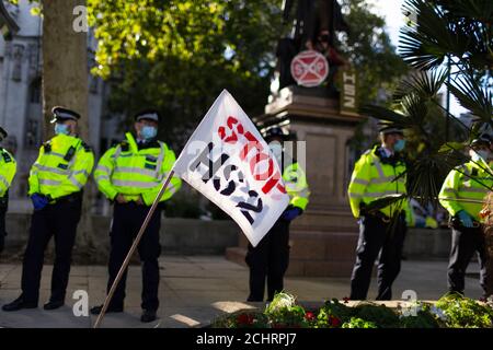 Un drapeau de protestation et la police pendant l'occupation des arbres de la rébellion HS2, Parliament Square, Londres, 5 septembre 2020 Banque D'Images