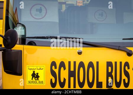 Autobus scolaire jaune à Abu Dhabi, Émirats arabes Unis, Dubaï, Émirats, Golfe, Moyen-Orient. Des signes et symboles de sensibilisation ont été écrits en langue arabe à Banque D'Images