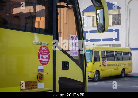 Autobus scolaire jaune à Abu Dhabi, Émirats arabes Unis, Dubaï, Émirats, Golfe, Moyen-Orient. Des signes et symboles de sensibilisation ont été écrits en langue arabe à Banque D'Images