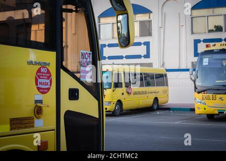 Autobus scolaire jaune à Abu Dhabi, Émirats arabes Unis, Dubaï, Émirats, Golfe, Moyen-Orient. Des signes et symboles de sensibilisation ont été écrits en langue arabe à Banque D'Images