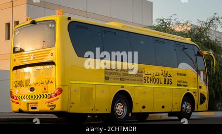 Autobus scolaire jaune à Abu Dhabi, Émirats arabes Unis, Dubaï, Émirats, Golfe, Moyen-Orient. Des signes et symboles de sensibilisation ont été écrits en langue arabe à Banque D'Images