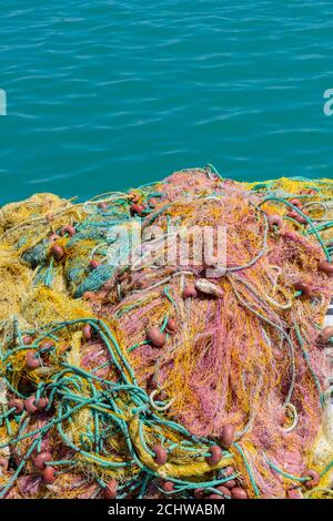 filets de pêche colorés se séchant au soleil sur le mur du port de zante zakynthos dans la mer ionienne en grèce. Banque D'Images