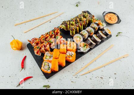 Vue de dessus de différents types de sushis servis sur un plateau de granit avec sauce et baguettes pour deux Banque D'Images