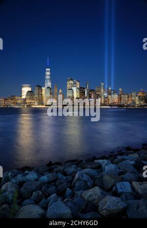 Vue nocturne sur les gratte-ciel de Lower Manhattan avec une vue annuelle de 9/11 Des lumières en hommage projetées dans le ciel avec le fleuve Hudson en premier plan Depuis Liberty State Park.New Jersey.USA Banque D'Images