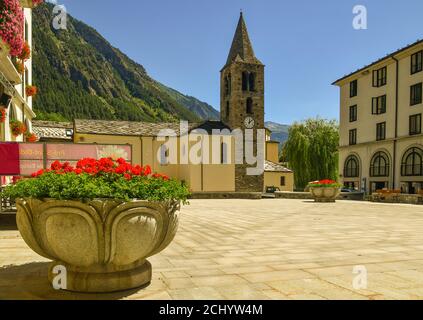 Place principale de l'ancien village alpin avec l'église Saint-Laurent (15ème-19ème c) et un pot à fleurs de géraniums, pré-Saint-Didier, Aoste, Italie Banque D'Images