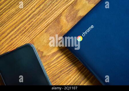 Blue Asus Chromebook et iPhone sur une table en bois, vue de dessus. Bichkek, Kirghizistan - 8 juin 2019. Banque D'Images