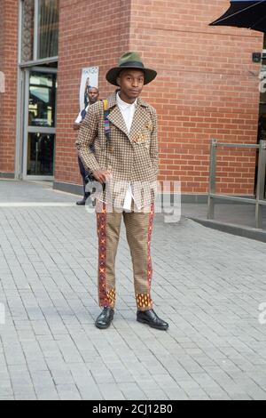 Homme africain bien habillé avec caméra à la semaine de la mode sud-africaine à Melrose Arch, Johannesburg, Afrique du Sud Banque D'Images