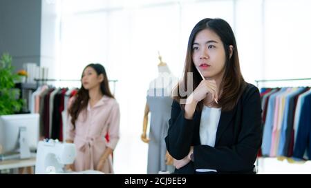 Portrait de jeune designer asiatique travaillant dans la boutique de vêtements Banque D'Images
