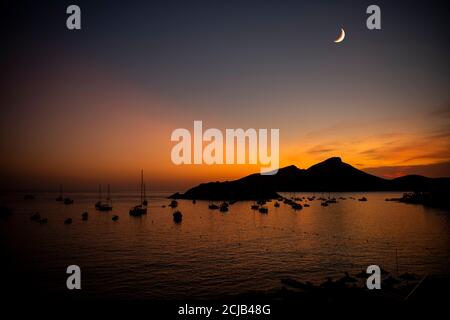 Vue de la ville de Sant Elm vers l'île du Dragon à Majorque - coucher de soleil. Ciel crépuscule avec lune. Banque D'Images