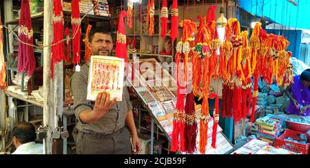 DISTRICT KATNI, INDE - 12 AOÛT 2019: Un commerçant indien qui fait la démonstration de la belle rakhi à vendre pendant le festival traditionnel hindou à la rue asiatique ma Banque D'Images