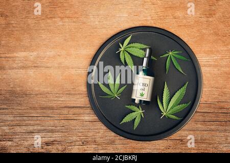 Cannabis produit médical, huile de CBD, avec feuilles de chanvre sur une table en bois Banque D'Images