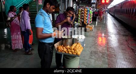 DISTRICT JABALPUR, INDE - 17 AOÛT 2019 : un manteur alimentaire mâle de chemin de fer indien qui vend des aloo banda à la plate-forme. Banque D'Images