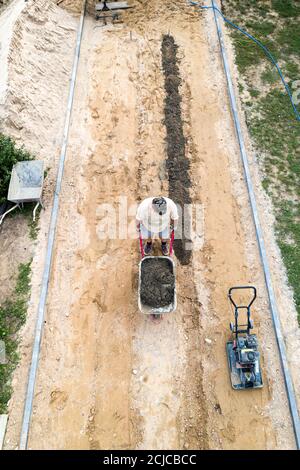 les ouvriers posent des carreaux de pavage, vue de dessus depuis un drone. Banque D'Images