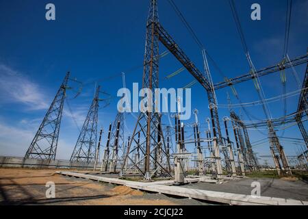 Centrale électrique. Sous-station de transformateur avec tours électriques (pylônes) et équipement sur fond bleu ciel. Banque D'Images