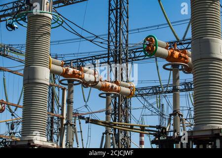 Centrale électrique. Sous-station de transformateur sur un bâtiment d'usine bleu et un fond ciel. Commutateur haute tension orange et gros plan de l'équipement. Banque D'Images