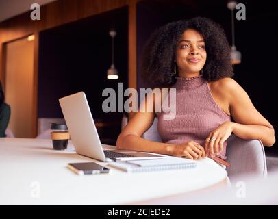 Portrait d'une femme d'affaires avec ordinateur portable lors d'une réunion socialement éloignée dans Bureau pendant la pandémie de santé Banque D'Images