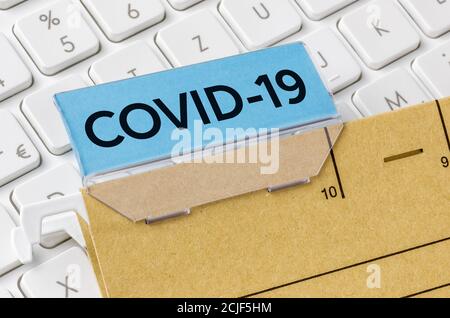 Un dossier de fichiers marron étiqueté COVID-19 Banque D'Images