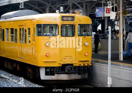 UN J.R. Train de banlieue série 115-2000 à la gare de Kurashiki. Banque D'Images