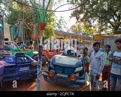 DISTRICT KATNI, INDE - 02 FÉVRIER 2020 : enfants indiens pauvres qui apprécient le swing de voiture pendant la saison du festival à l'événement de bazar local. Banque D'Images